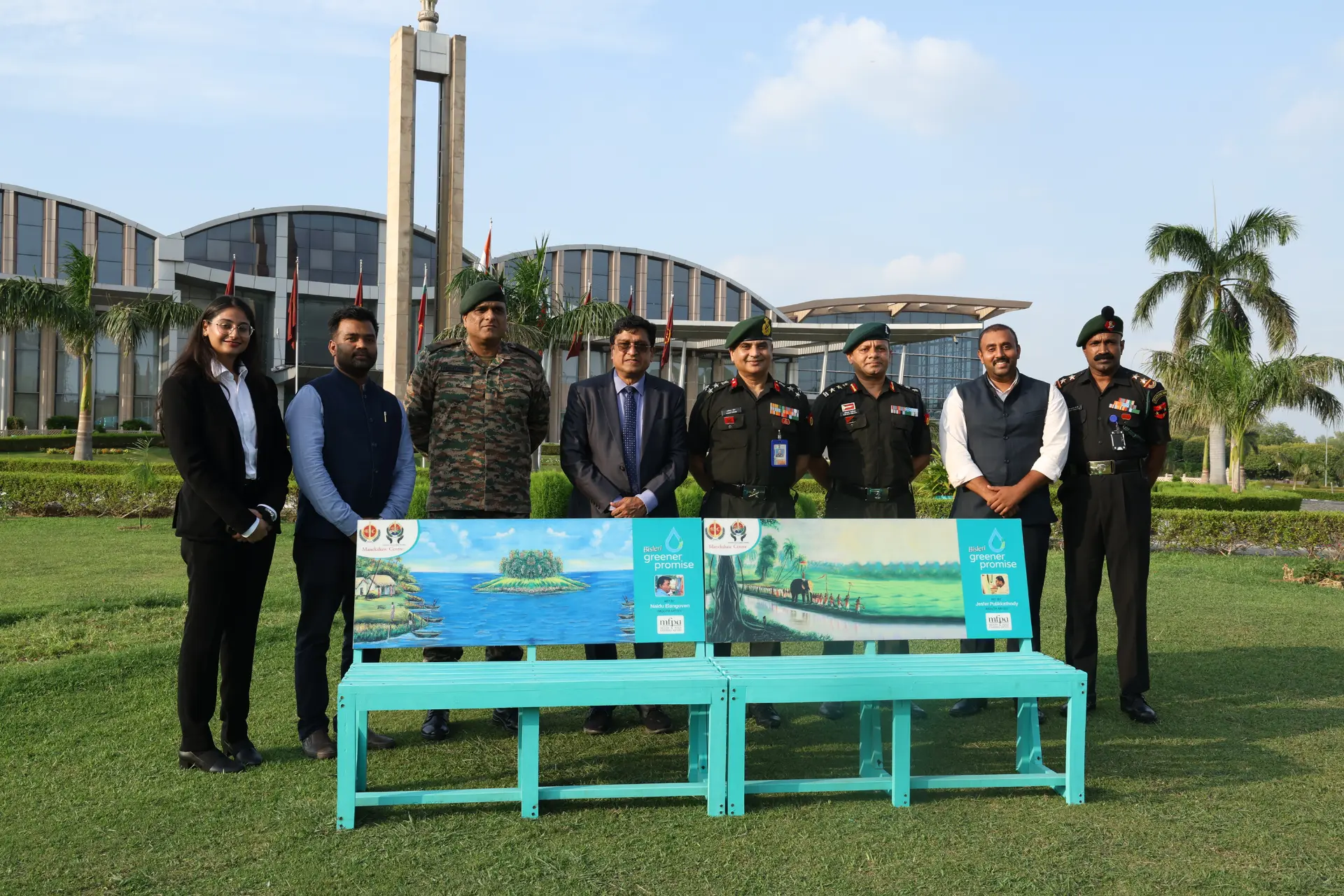 Bisleri team and officials stand behind two painted recycled plastic benches at an outdoor installation event
